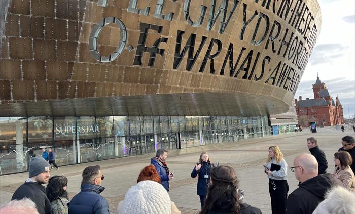 Group of adults standing in front of Wales Millennium Centre